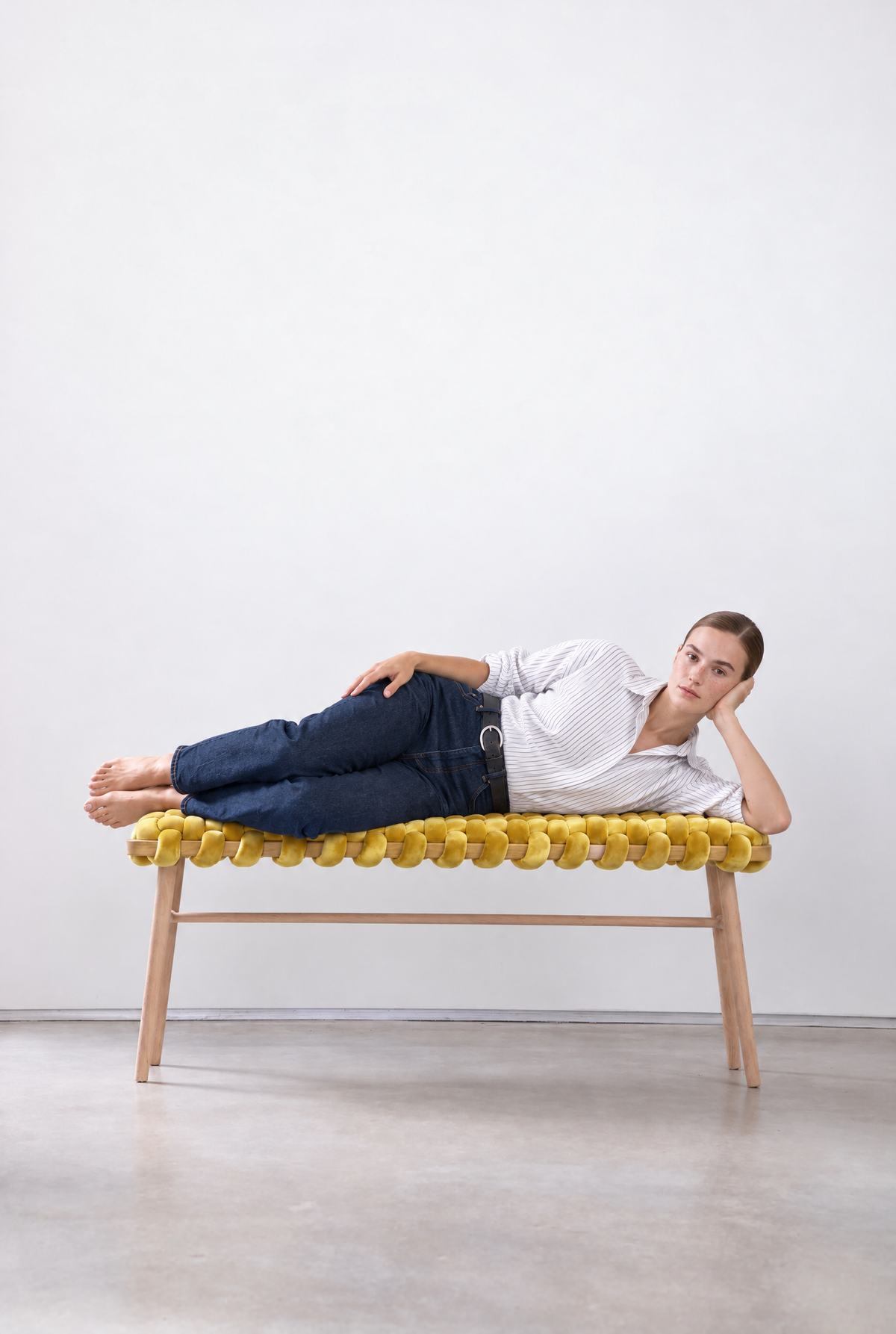 Woman lying on a 47 inch yellow velvet woven bench