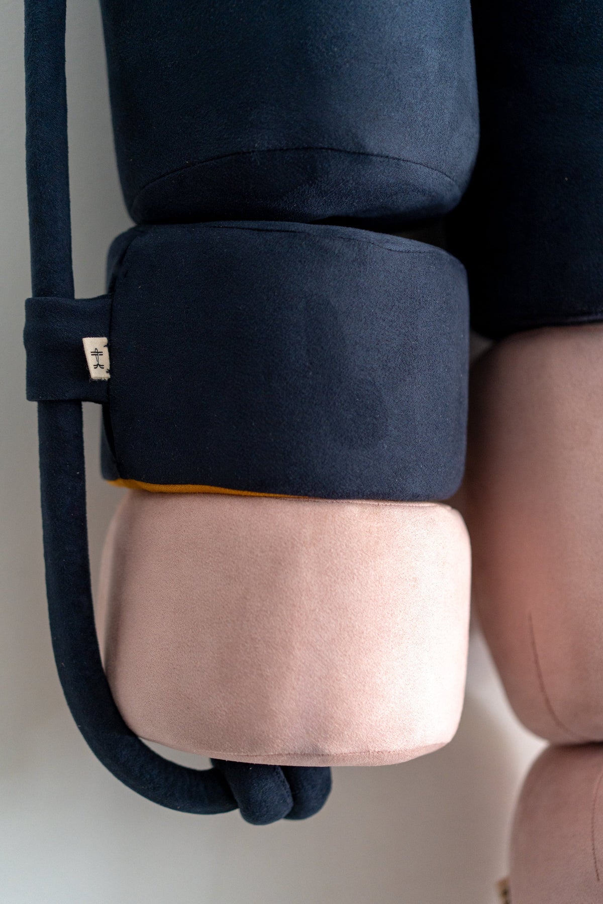 Close-up of a navy and pink vegan suede buoy cushion