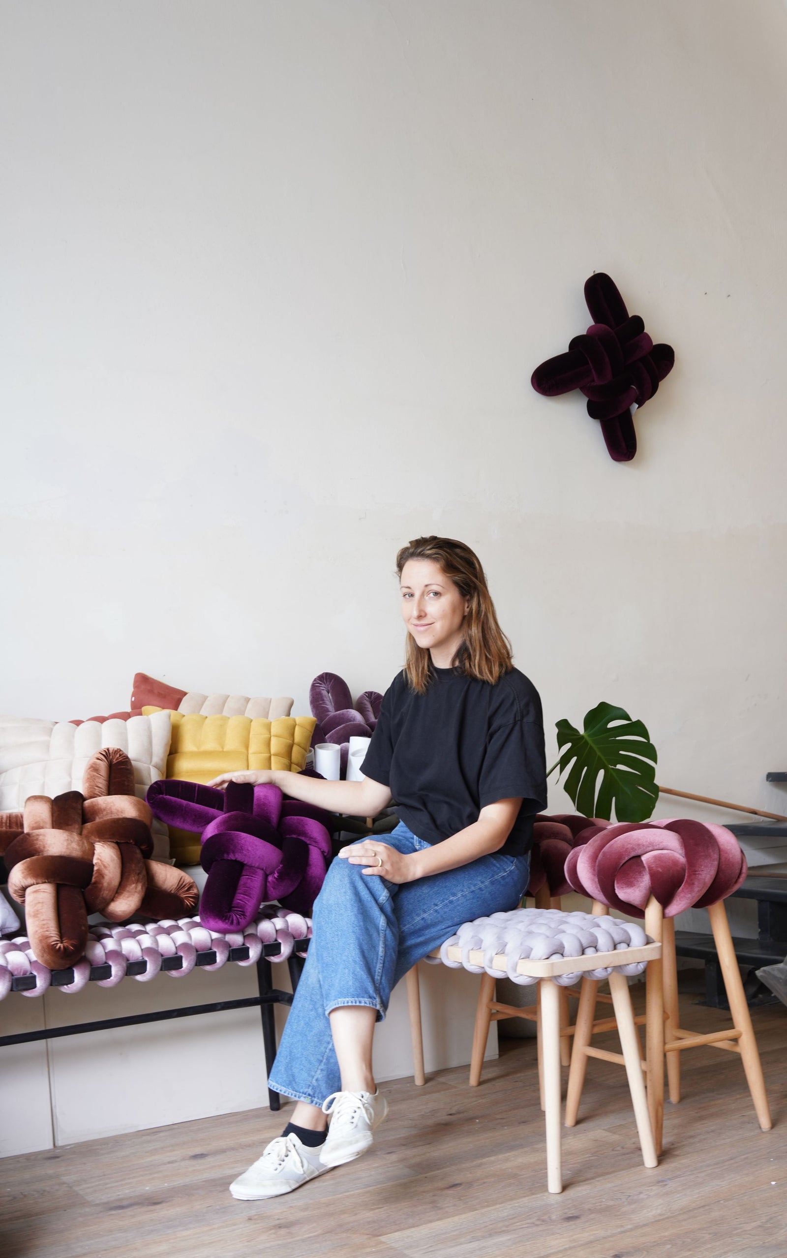 Woman sitting on a colorful chair in a modern living room.