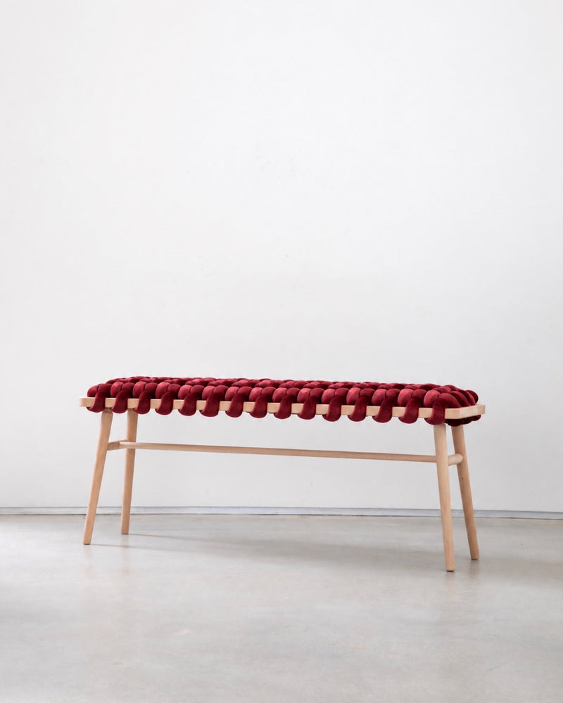 47 inch maroon velvet woven bench with a beechwood frame against a white wall