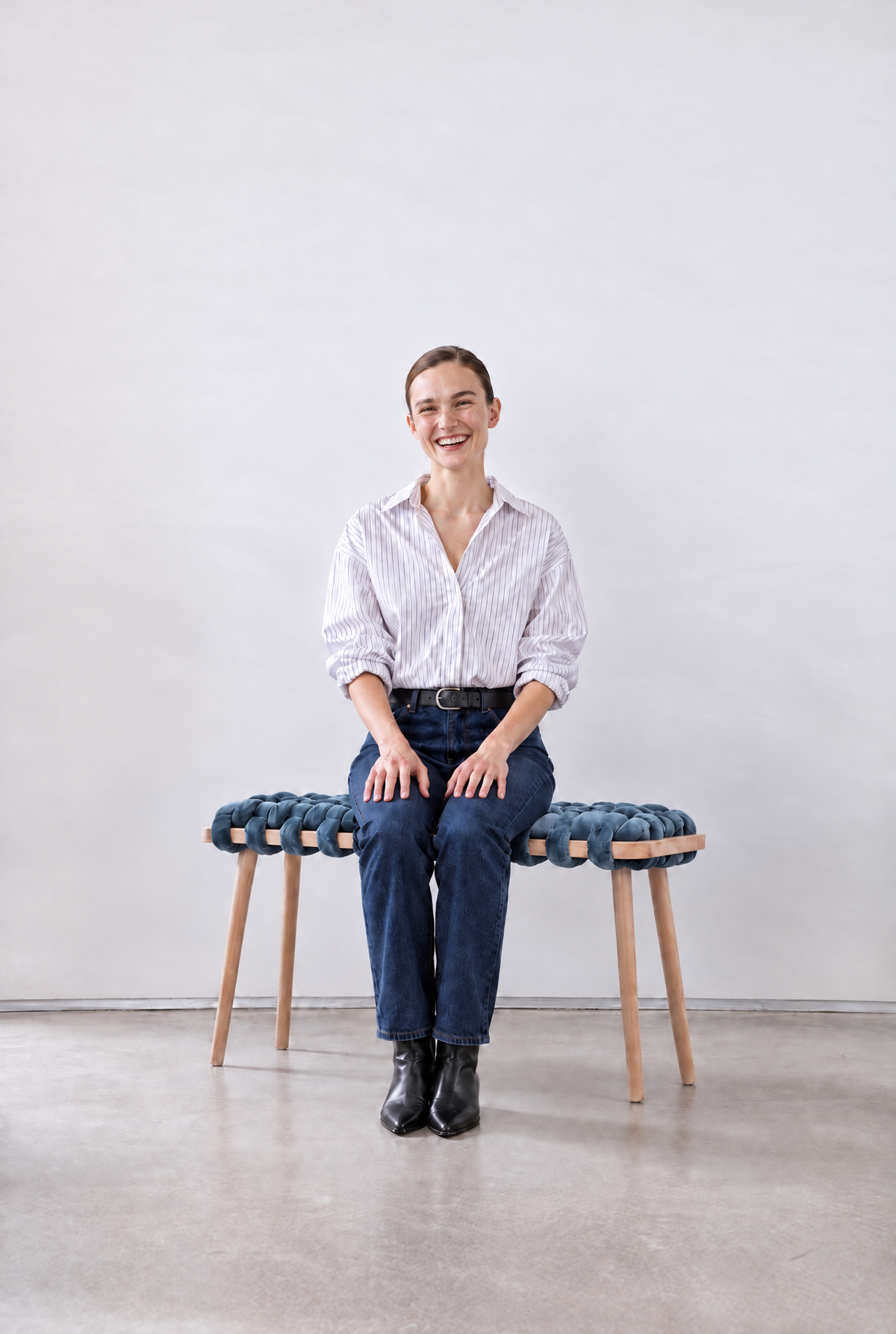 Smiling woman sitting on a 47 inch ocean blue velvet woven bench