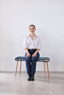 Smiling woman sitting on a 47 inch ocean blue velvet woven bench