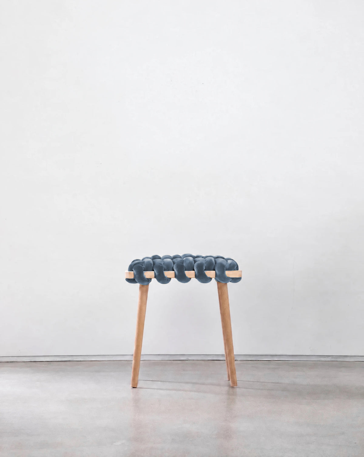 Ocean blue velvet woven stool with a beechwood frame, front view