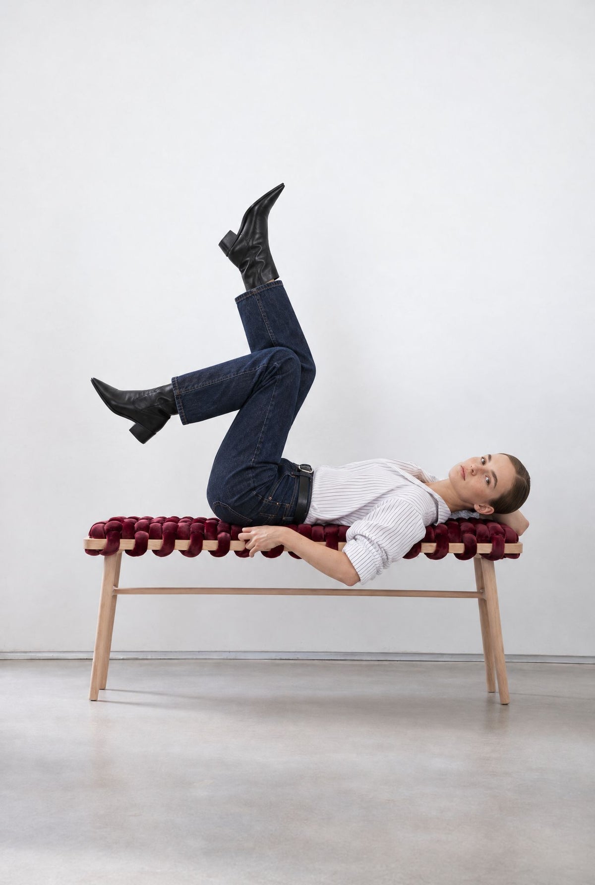 Woman lounging on a 47 inch burgundy velvet woven bench