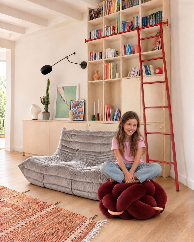 Girl sitting on the (M) Maroon Knot Ottoman