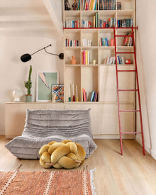 (M) Sunlight Yellow Knot Ottoman in front of a light grey sofa