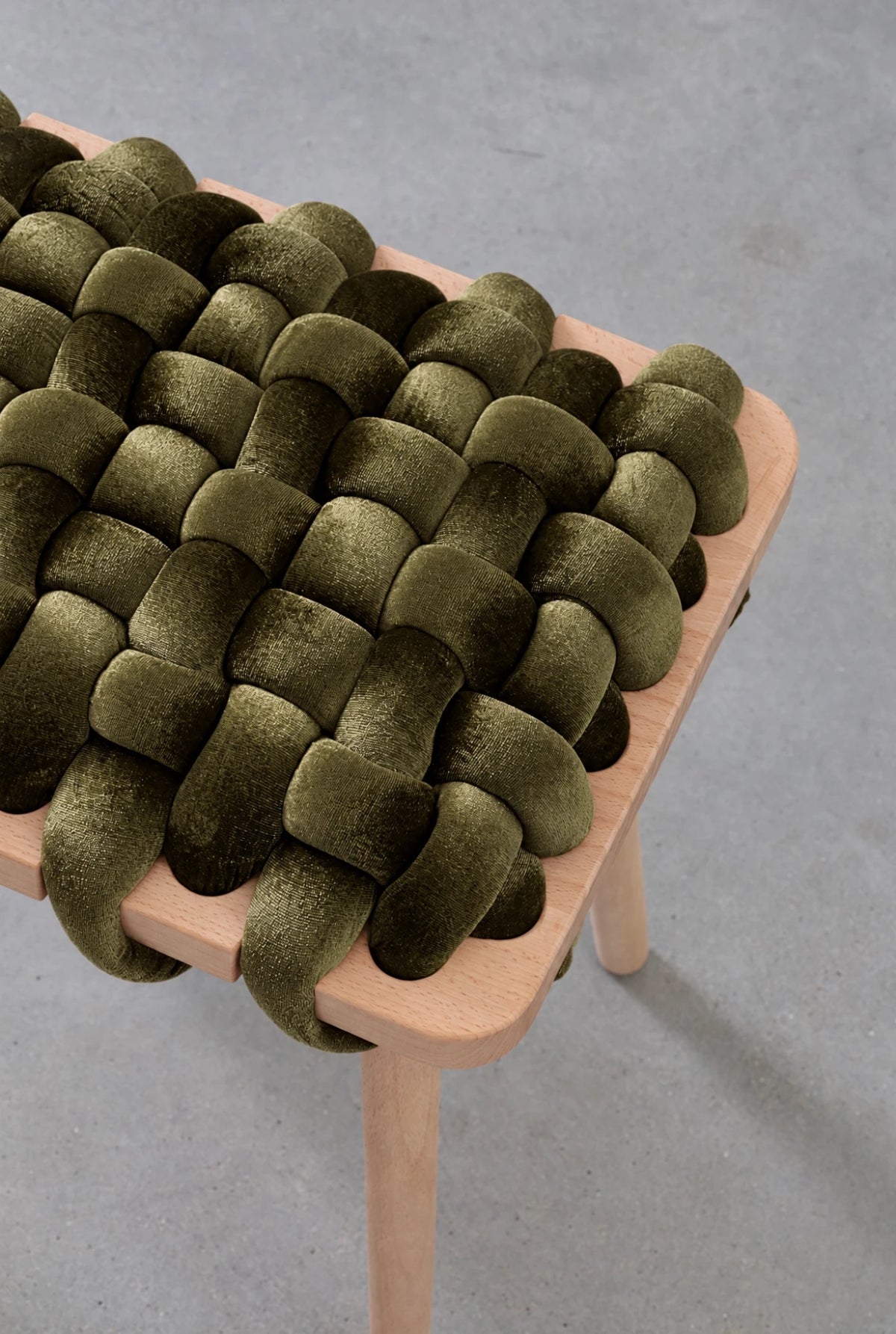 Close-up of an olive green velvet woven stool